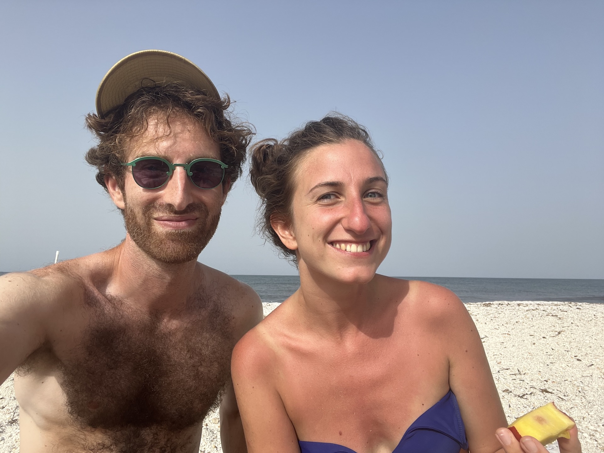 Eleonora and Aaron sitting at Spiaggia Le Saline in Sardinia.
